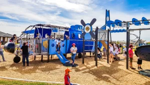 Niños jugando en estructuras temáticas y figuras 3D en parque infantil en Panamá